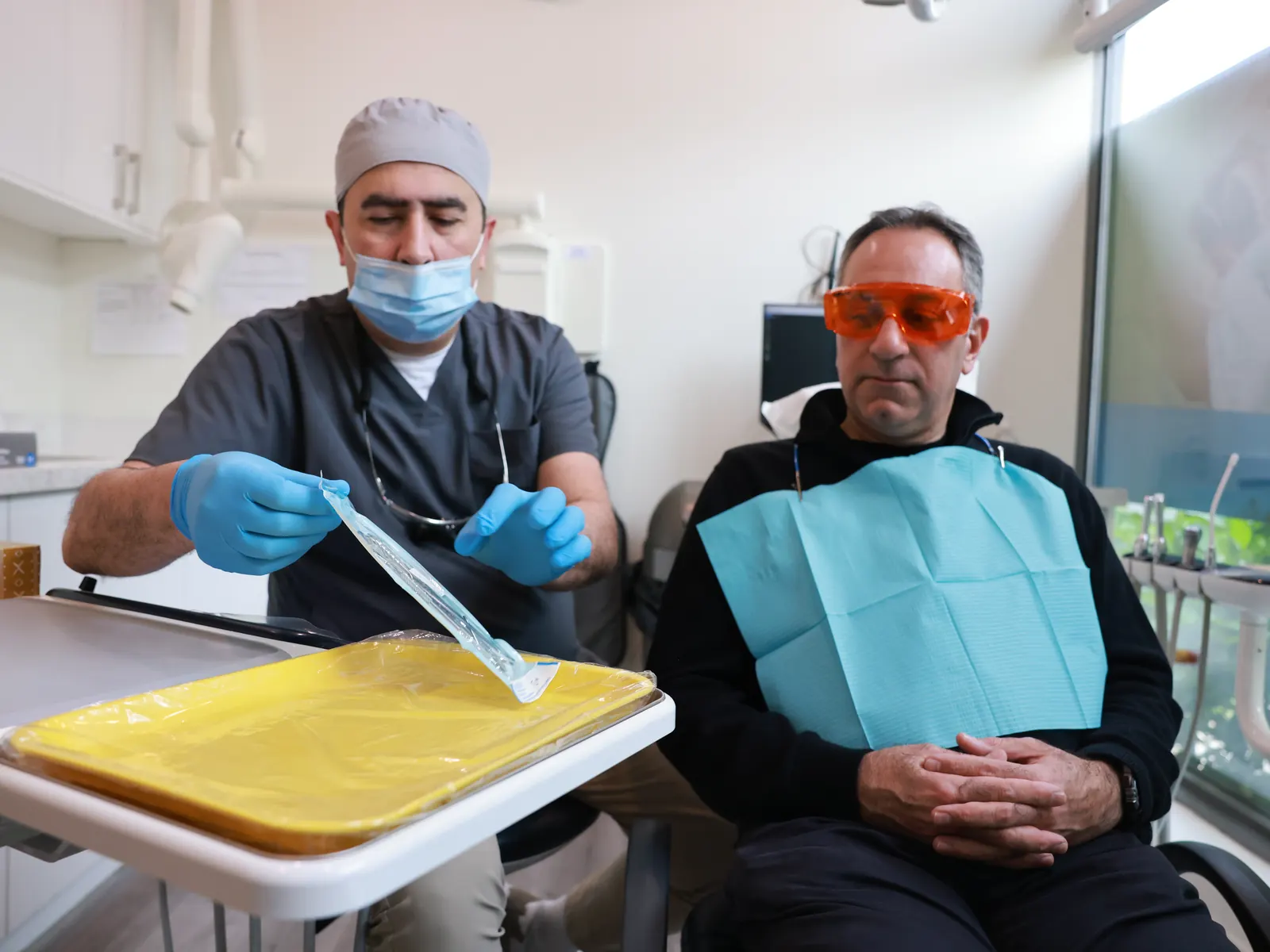 Dentist walking a patient through the next step of a dental visit in a modern operatory