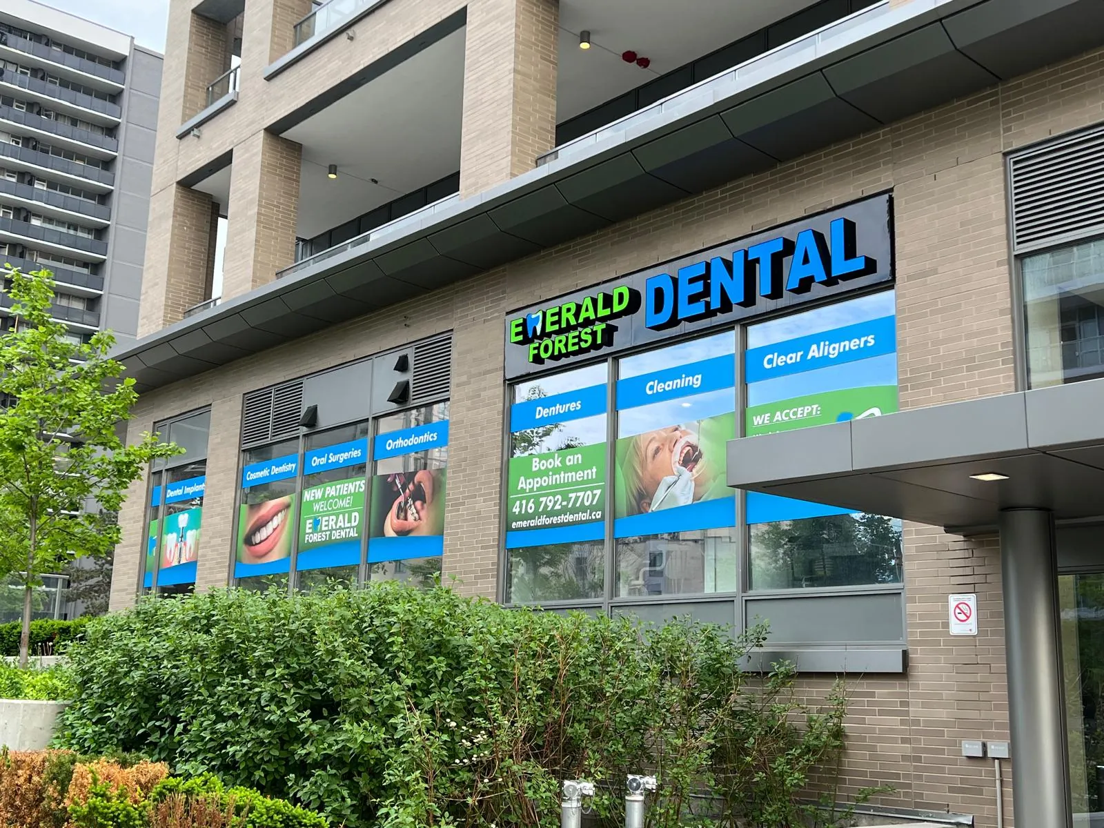 Street-level storefront of Emerald Forest Dental Clinic at 56 Forest Manor Rd, North York, with the clinic sign and windows listing dental services
