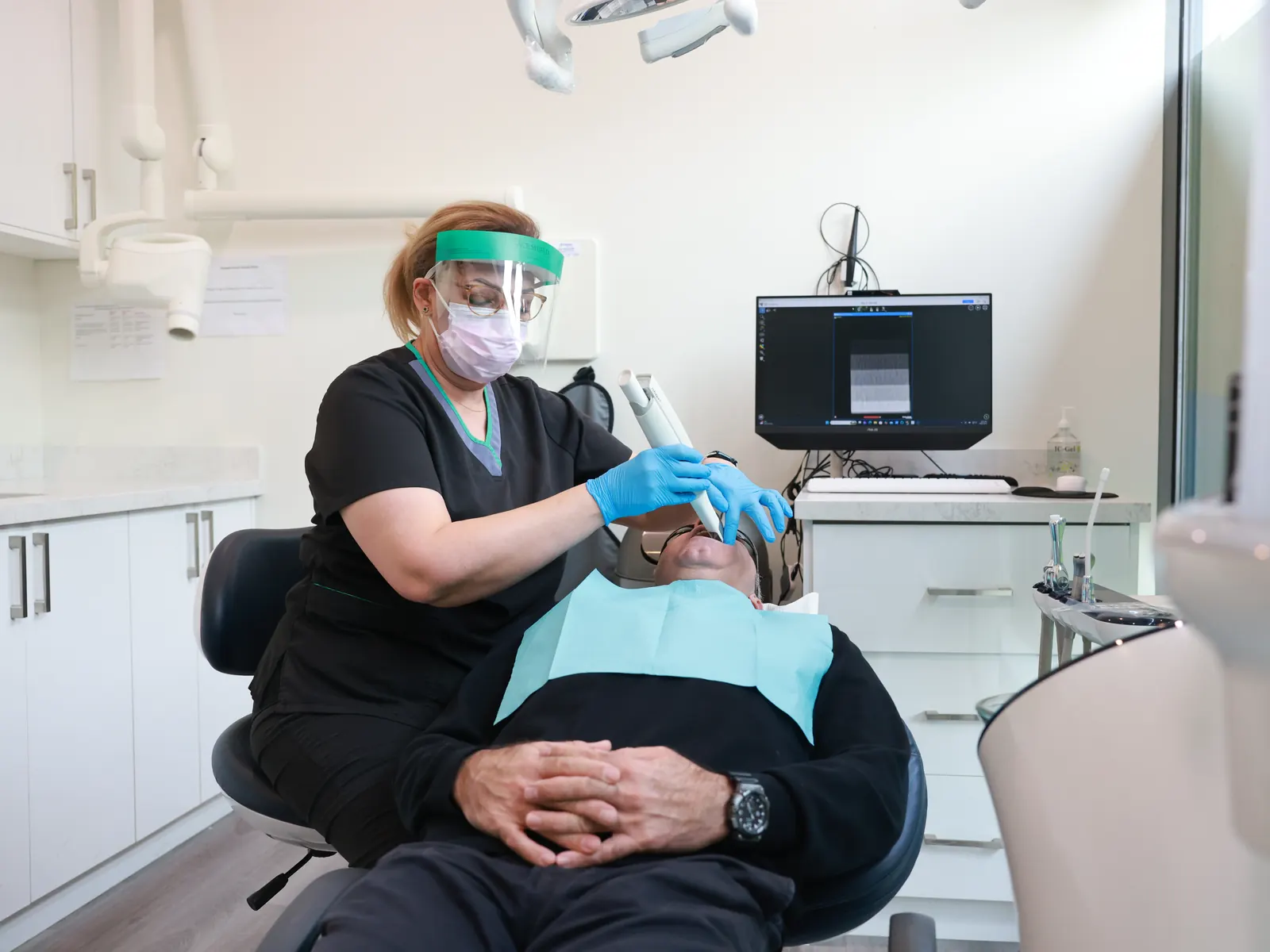 Hygienist cleaning a patient's teeth at Emerald Forest Dental Clinic in North York