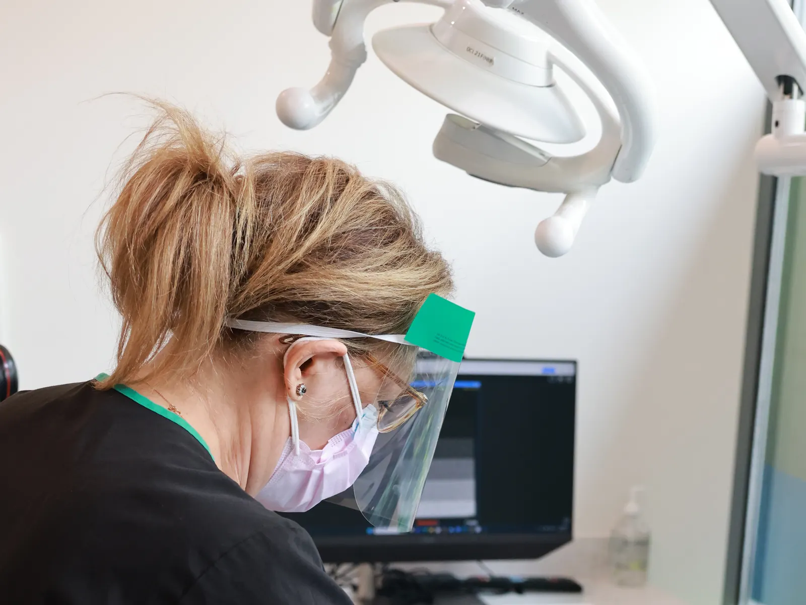 Hygienist leaning in to examine a patient at Emerald Forest Dental Clinic in North York